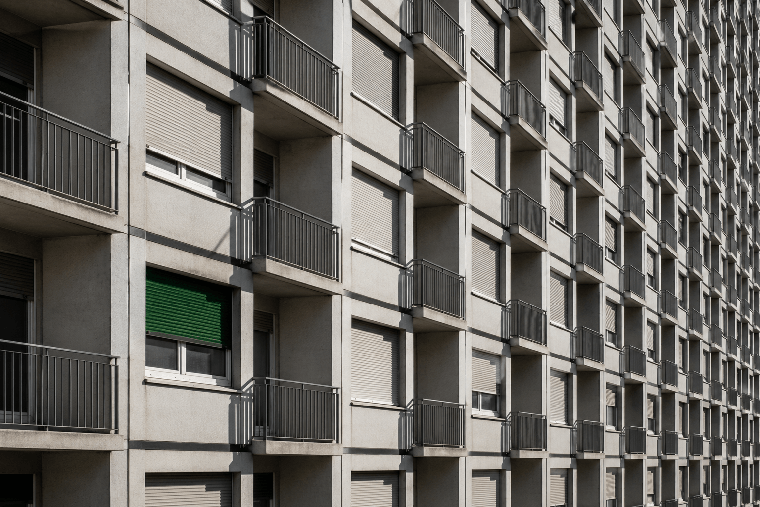 La façade d'un immeuble locatif, balcons et stores en enfilade