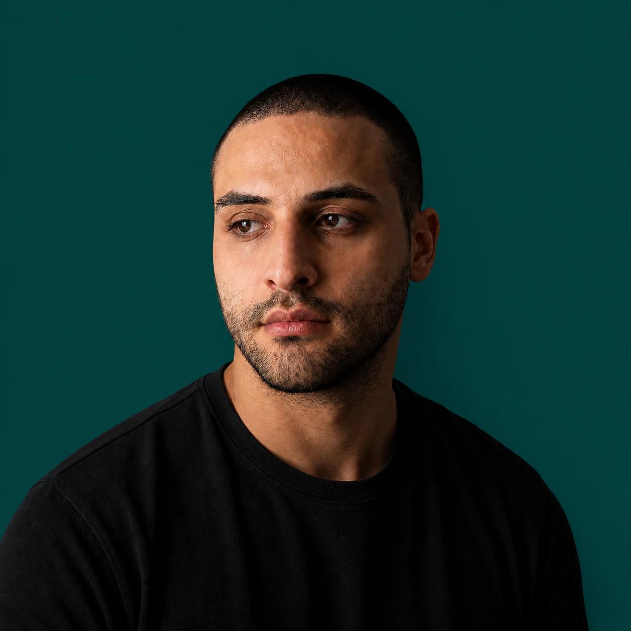 Naaser, développeur indépendant Tacelo, photographié sur fond vert sapin